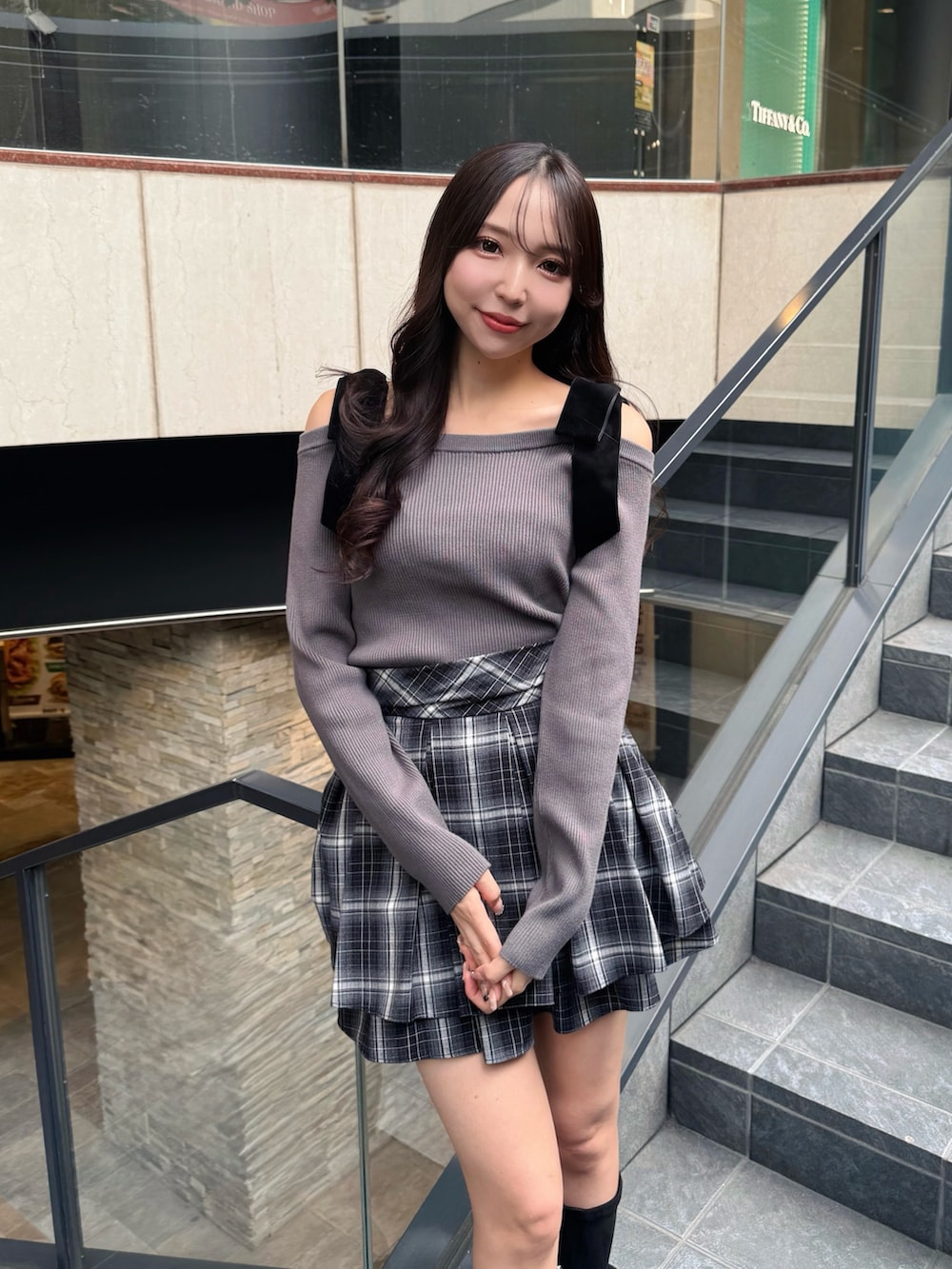 グレー系のニット/セーター、ブラック系のスカートを着用したレディースの秋コーディネートの4枚目の写真