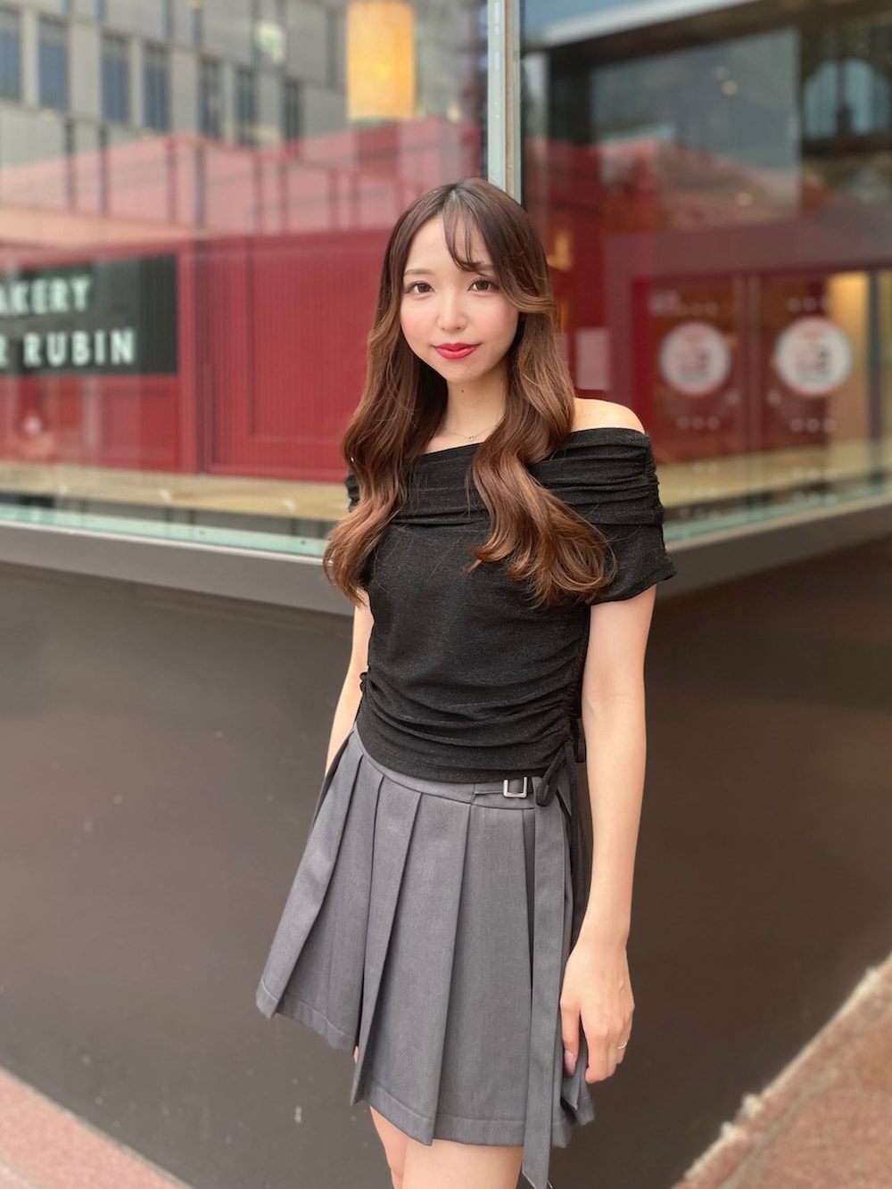 ブラック系のTシャツ/カットソー、グレー系のスカート、ブラック系のサンダルを着用したレディースの夏コーディネートの2枚目の写真