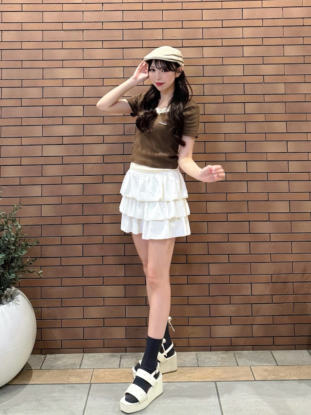 ブラウン系のTシャツ/カットソー、ホワイト系のスカート、ホワイト系のサンダルを着用したレディースの夏コーディネートの2枚目の写真
