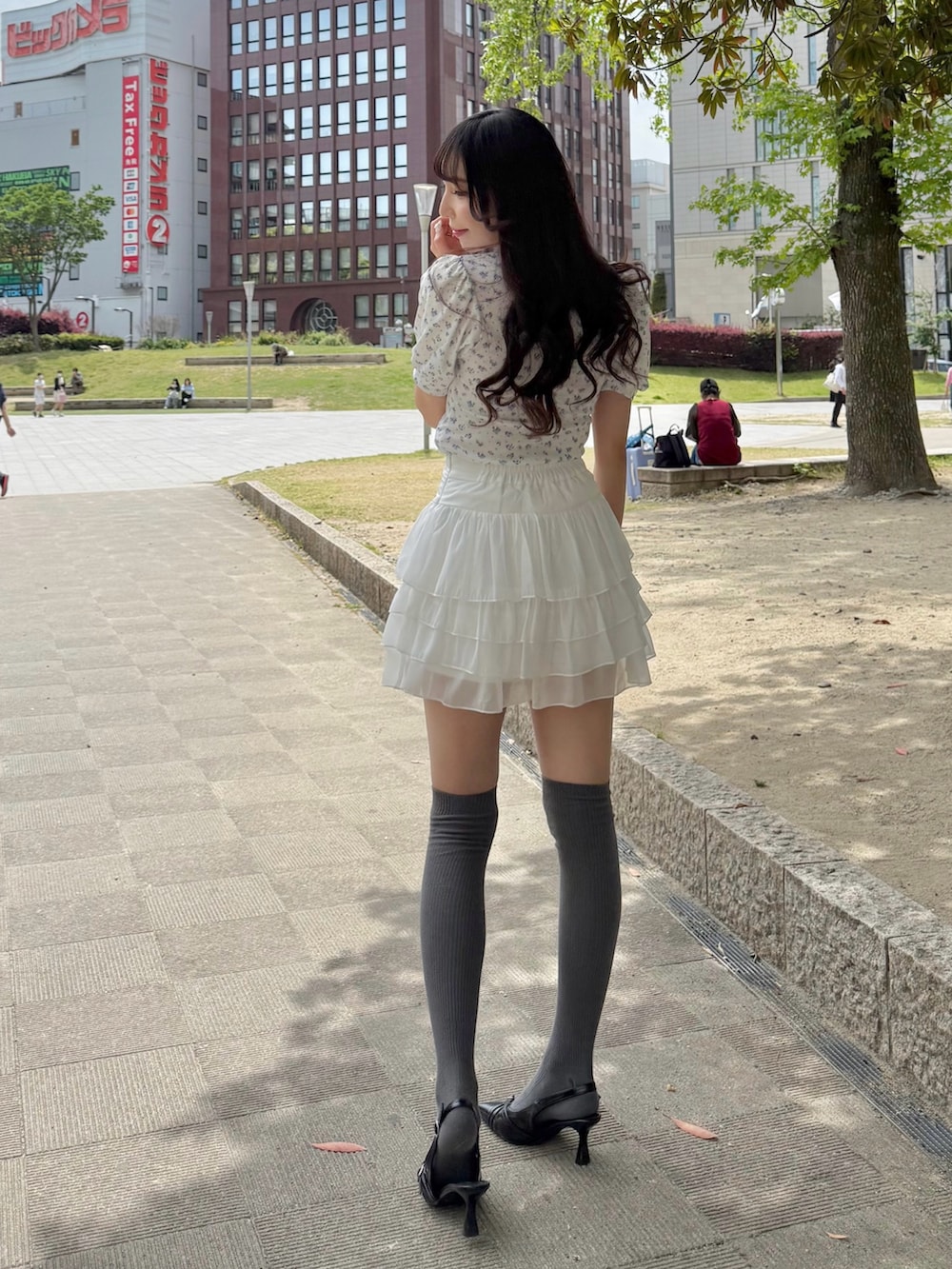 ホワイト系のTシャツ/カットソー、ホワイト系のスカート、ブラック系のパンプスを着用したレディースの春コーディネートの2枚目の写真