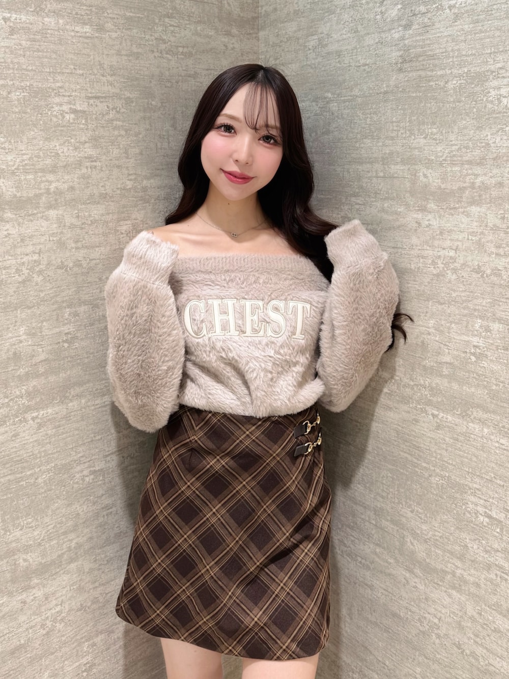 ピンク系のニット/セーター、ブラウン系のスカート、ブラウン系のブーツを着用したレディースの秋コーディネートの6枚目の写真