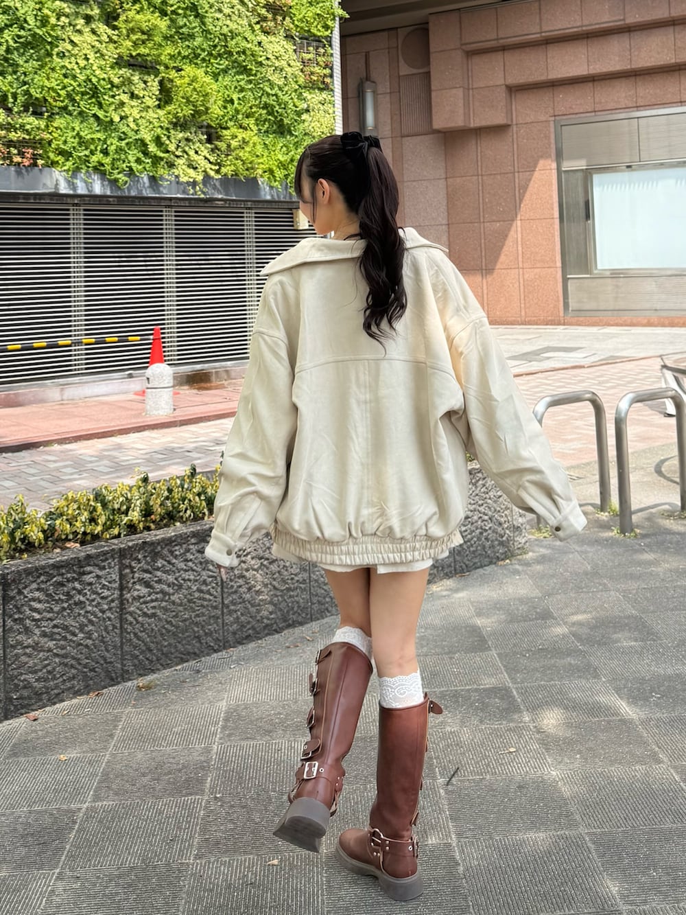 ホワイト系のブルゾン、ホワイト系のキャミソール、ホワイト系のスカートを着用したレディースの秋コーディネートの3枚目の写真