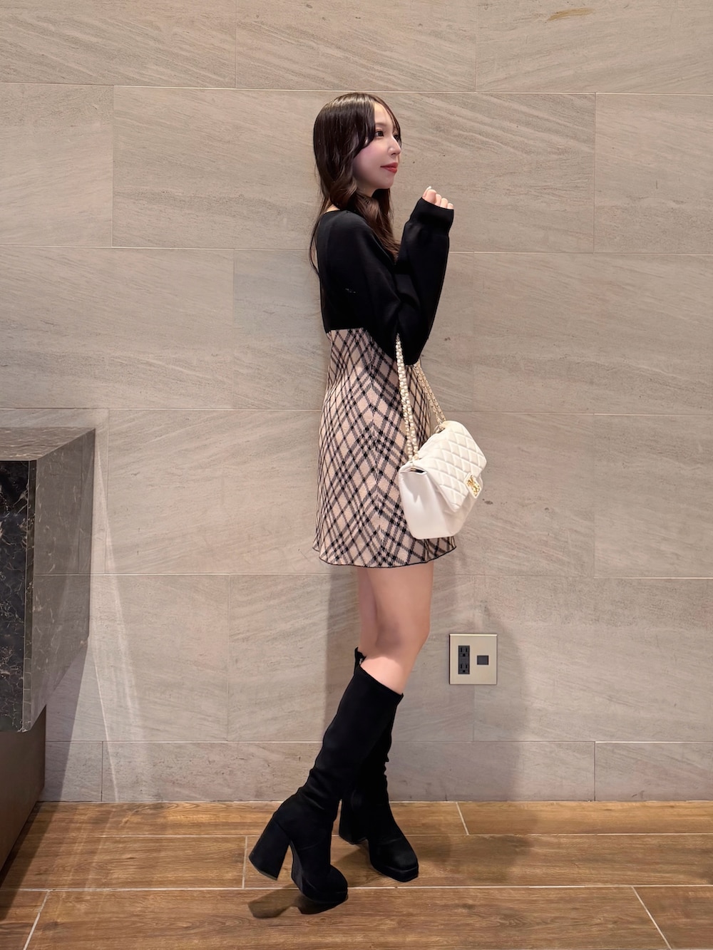 ベージュ系のワンピース、ホワイト系のショルダーバッグを着用したレディースの冬コーディネートの4枚目の写真