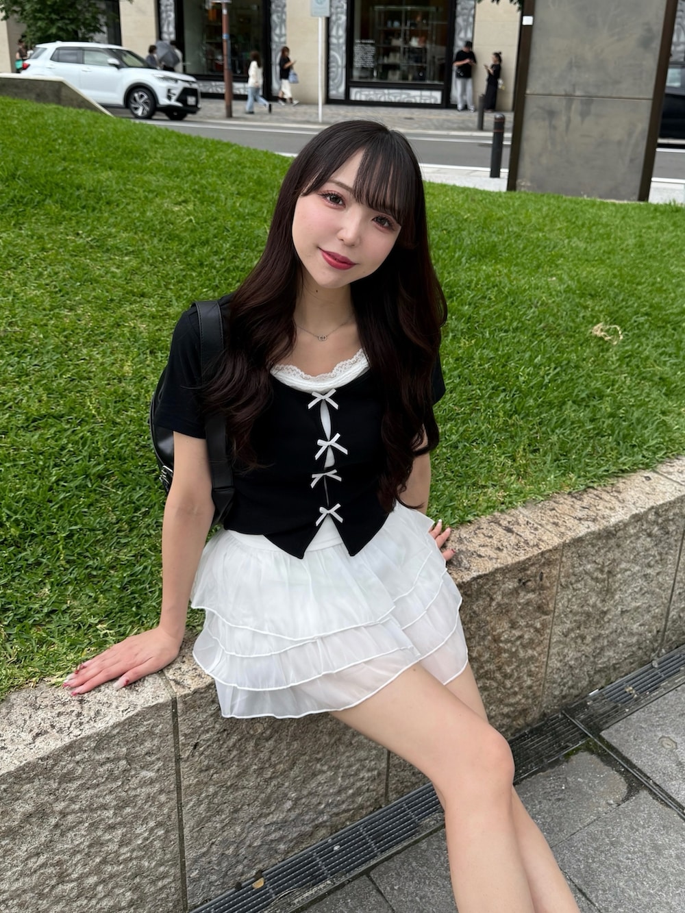 ブラック系のTシャツ/カットソー、ホワイト系のスカート、ブラック系のサンダルを着用したレディースの夏コーディネートの4枚目の写真