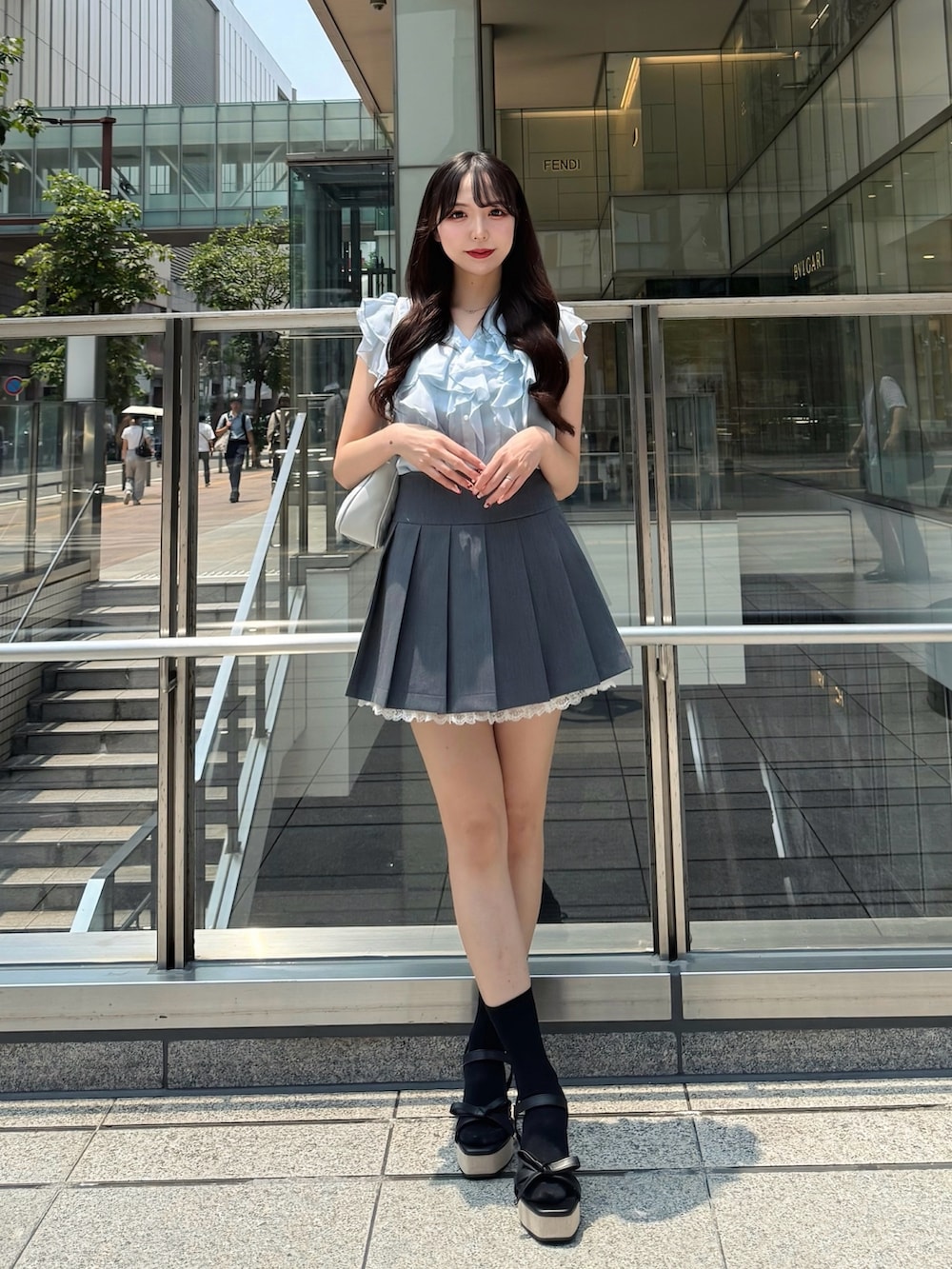 ブルー系のシャツ/ブラウス、グレー系のスカート、ブラック系のサンダルを着用したレディースの夏コーディネートの3枚目の写真