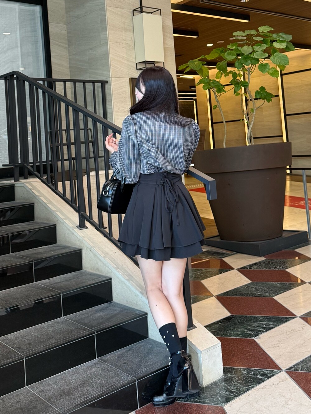 ブルー系のシャツ/ブラウス、ブラック系のハンドバッグ、ブラック系のスカートを着用したレディースの秋コーディネートの2枚目の写真