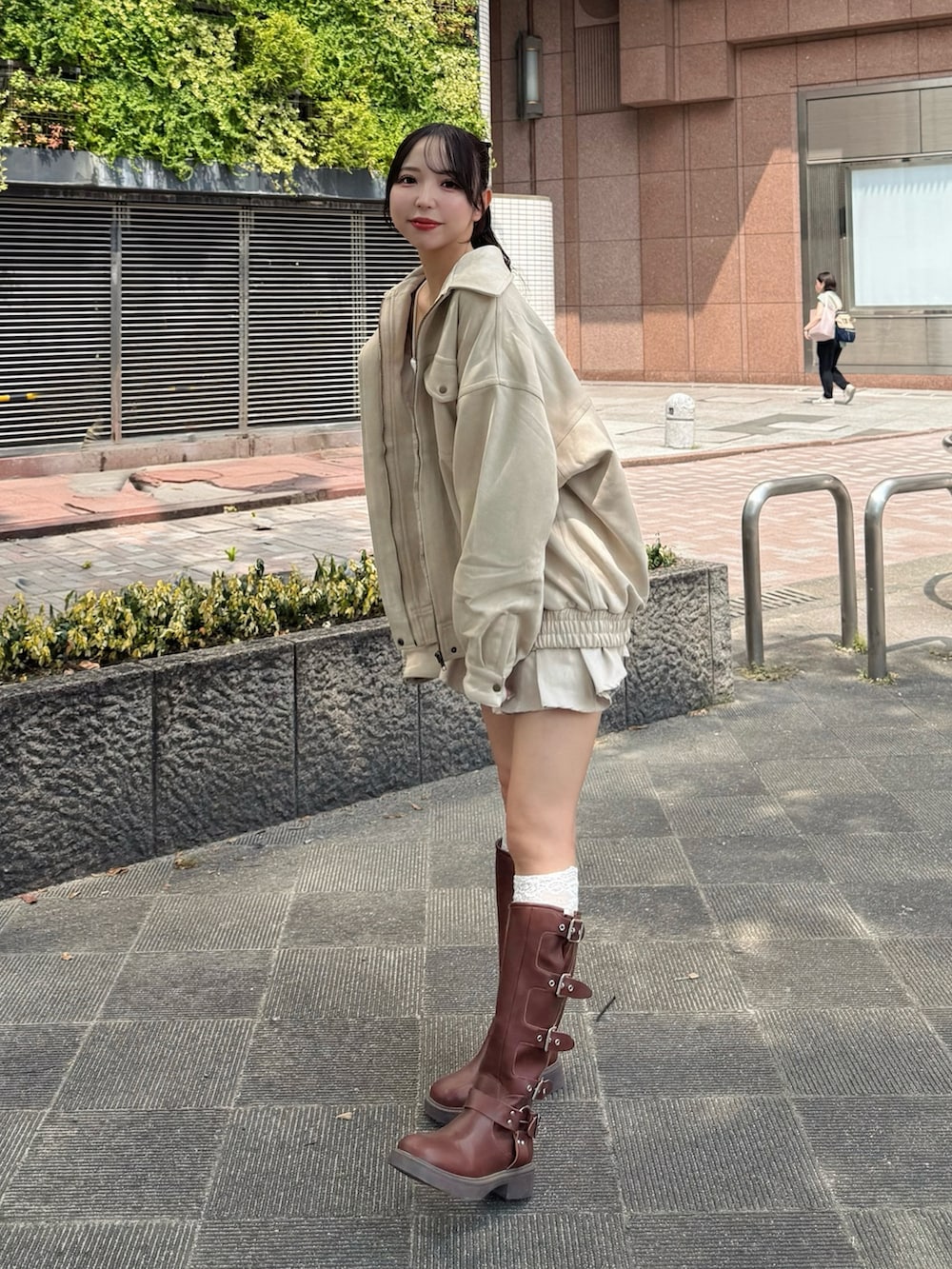 ホワイト系のブルゾン、ホワイト系のキャミソール、ホワイト系のスカートを着用したレディースの秋コーディネートの4枚目の写真