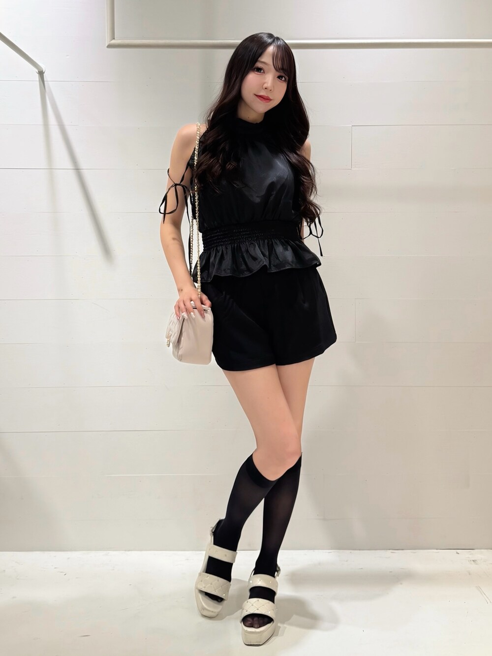 ブラック系のその他パンツ、ブラック系のシャツ/ブラウス、ホワイト系のショルダーバッグを着用したレディースの夏コーディネートの2枚目の写真