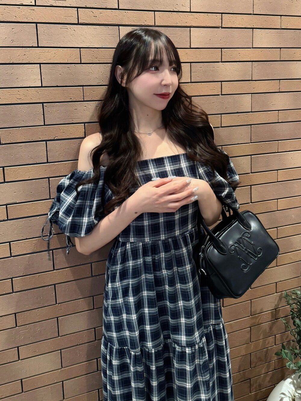 ブルー系のワンピース、ブラック系のハンドバッグ、ホワイト系のサンダルを着用したレディースの夏コーディネートの6枚目の写真