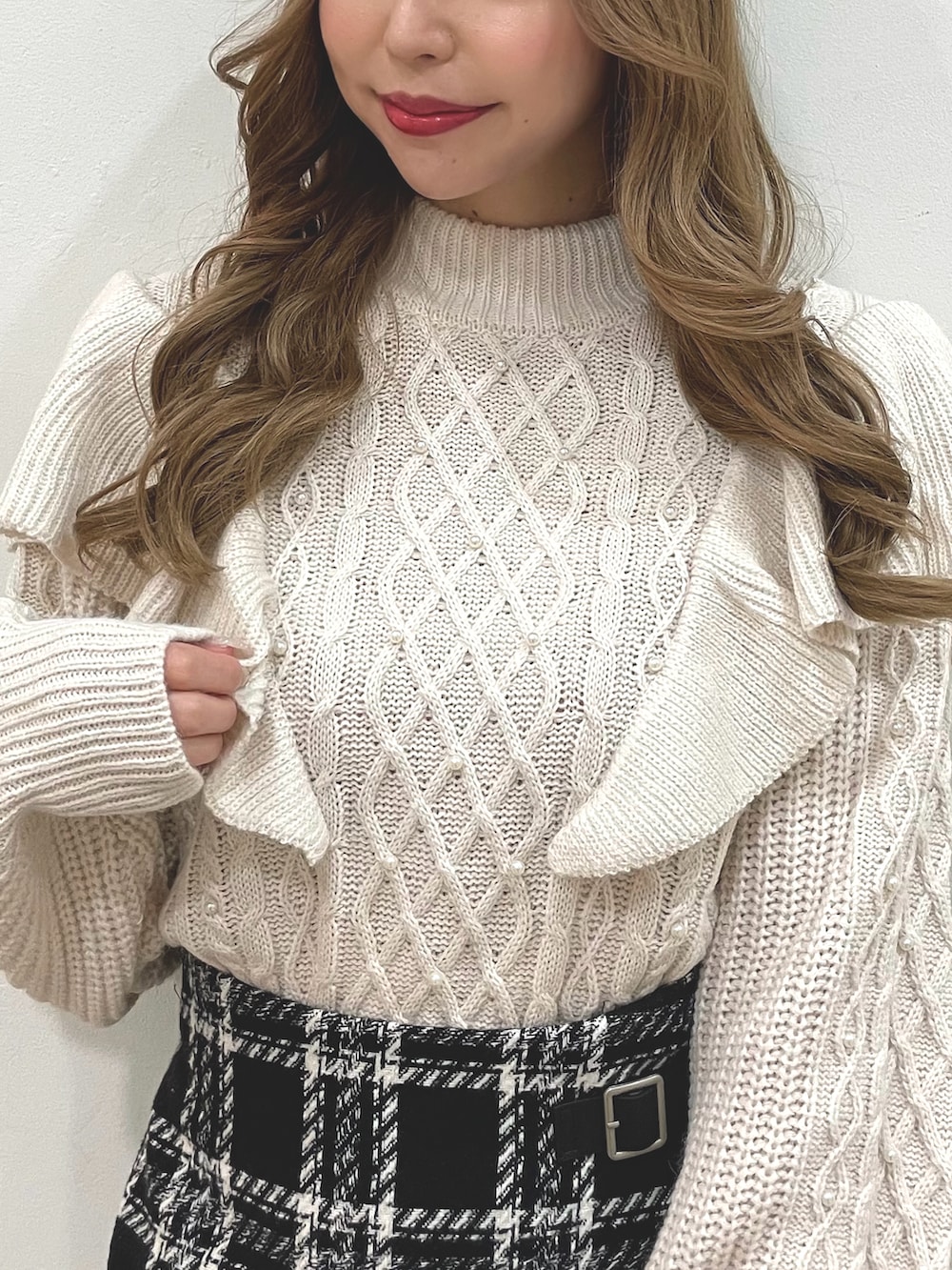 ホワイト系のニット/セーター、ブラック系のスカート、ブラック系のショルダーバッグを着用したレディースの冬コーディネートの2枚目の写真