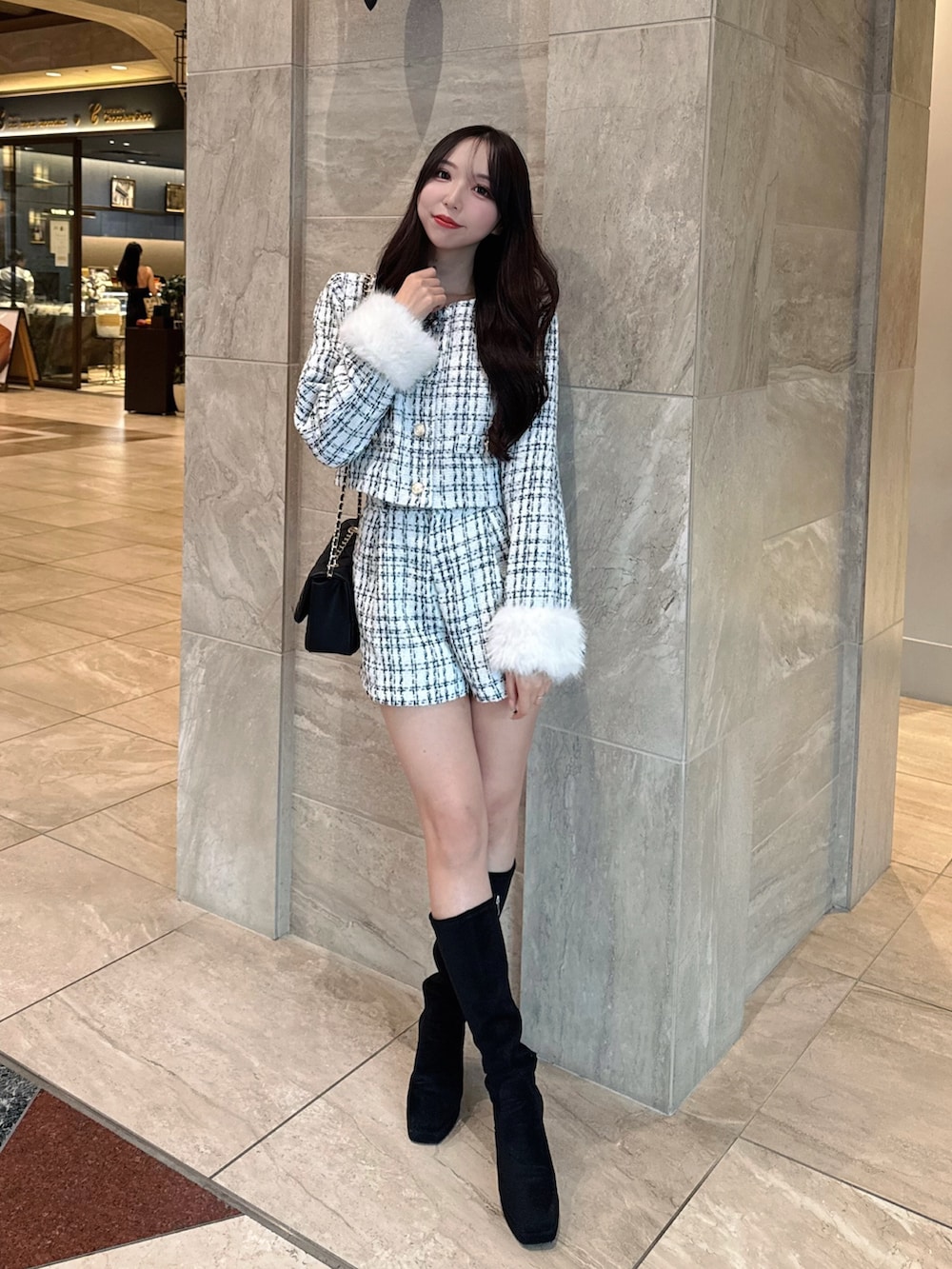 ホワイト系のノーカラージャケット、ホワイト系のその他パンツ、ブラック系のショルダーバッグを着用したレディースの秋コーディネートの3枚目の写真