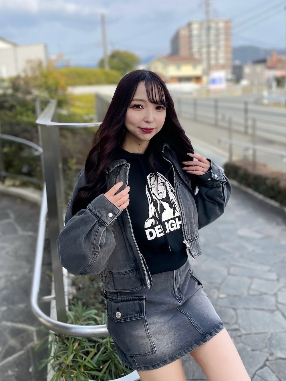 グレー系のデニムジャケット、ブラック系のパーカー、グレー系のデニムスカートを着用したレディースの春コーディネートの4枚目の写真