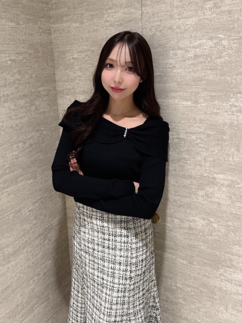 ブラック系のニット/セーター、ホワイト系のスカートを着用したレディースの秋コーディネートの3枚目の写真