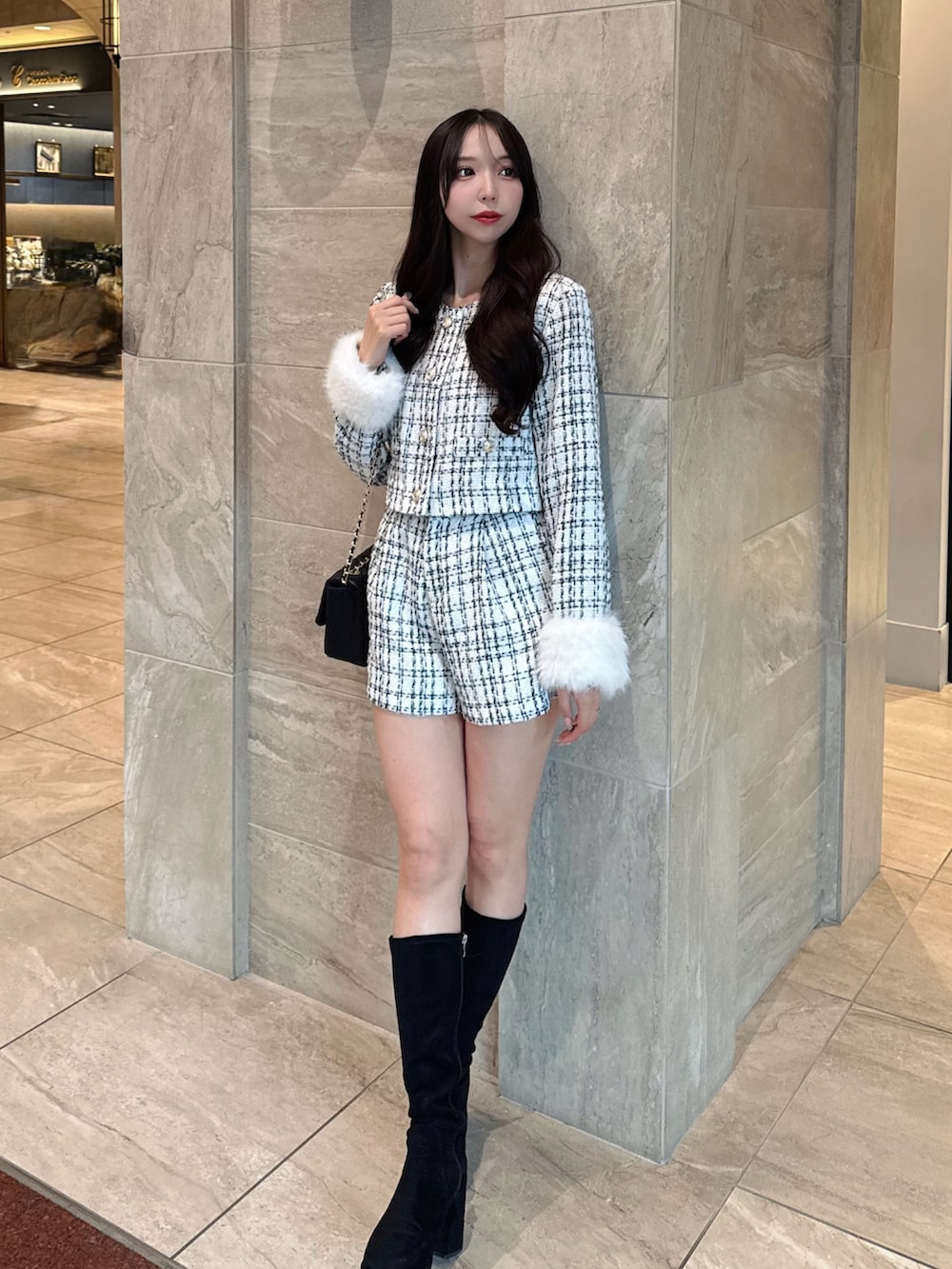 ホワイト系のノーカラージャケット、ホワイト系のその他パンツ、ブラック系のショルダーバッグを着用したレディースの秋コーディネートの2枚目の写真