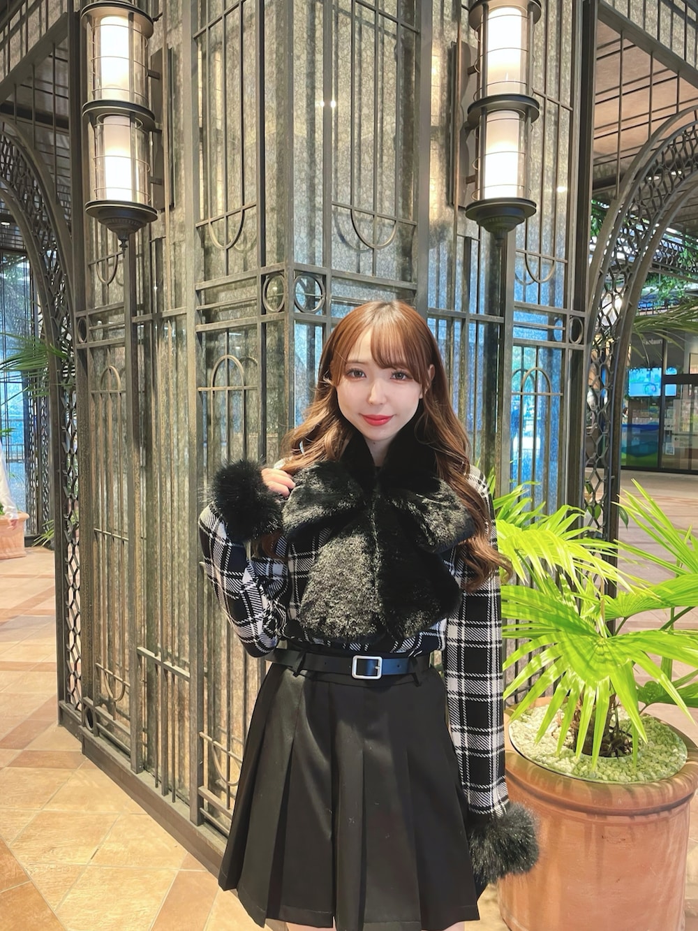 ブラック系のニット/セーター、ブラック系のスカート、ブラック系のマフラーを着用したレディースの秋コーディネートの3枚目の写真