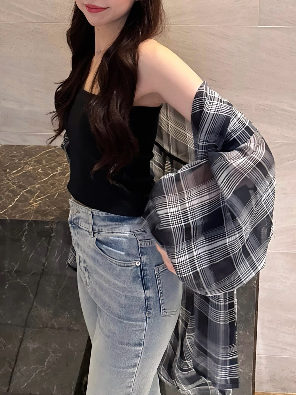 ブラック系のシャツ/ブラウス、ブラック系のキャミソール、ブルー系のデニムパンツを着用したレディースの夏コーディネートの3枚目の写真