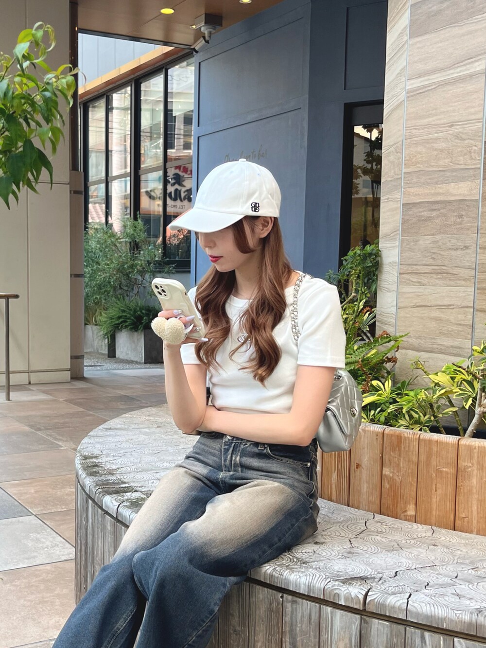 ブルー系のデニムパンツ、ホワイト系のTシャツ/カットソー、シルバー系のショルダーバッグを着用したレディースの夏コーディネートの3枚目の写真