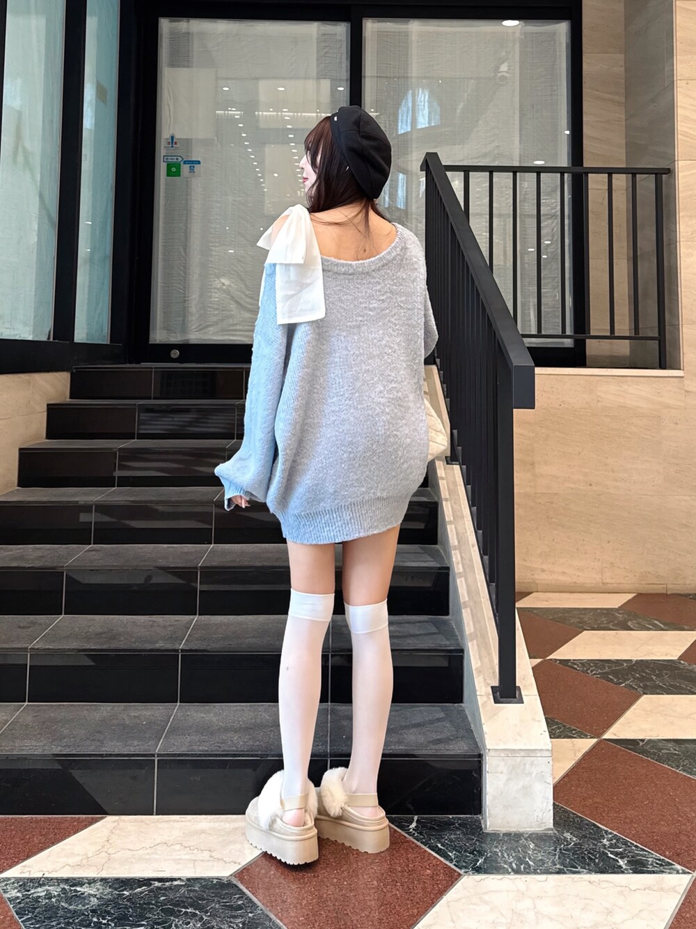 ブルー系のチュニック、ベージュ系のブーツ、ホワイト系のショルダーバッグを着用したレディースの冬コーディネートの5枚目の写真