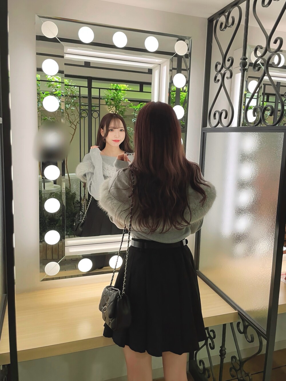 グレー系のニット/セーター、ブラック系のスカートを着用したレディースの秋コーディネートの2枚目の写真