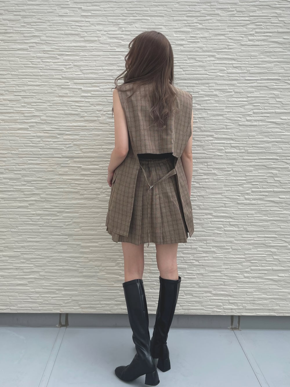 ブラウン系のベスト、ブラック系のキャミソール、ブラウン系のスカートを着用したレディースの夏コーディネートの2枚目の写真