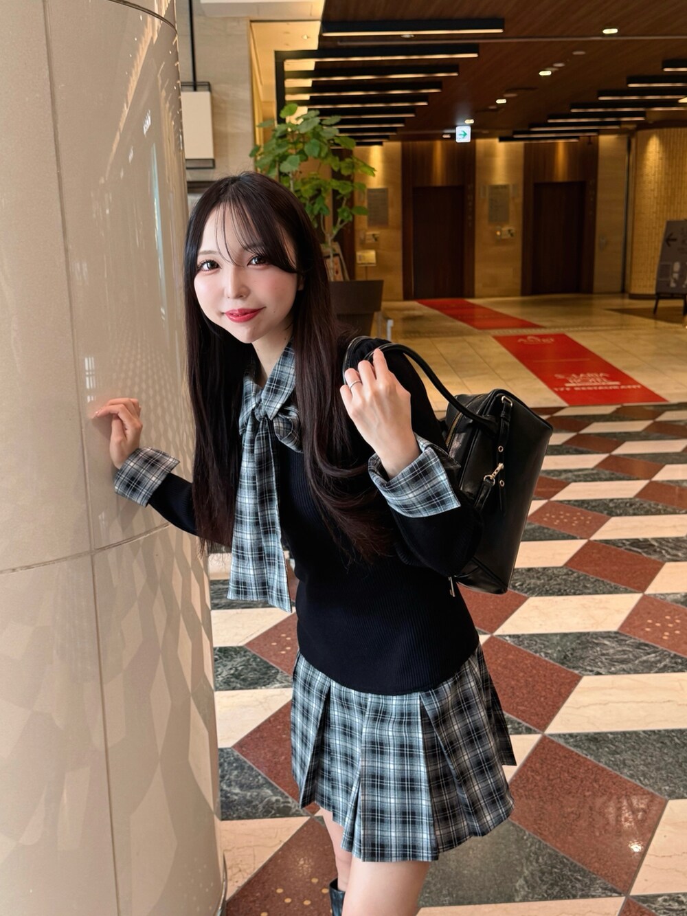 ブラック系のワンピース、ブラック系のハンドバッグを着用したレディースの秋コーディネートの6枚目の写真