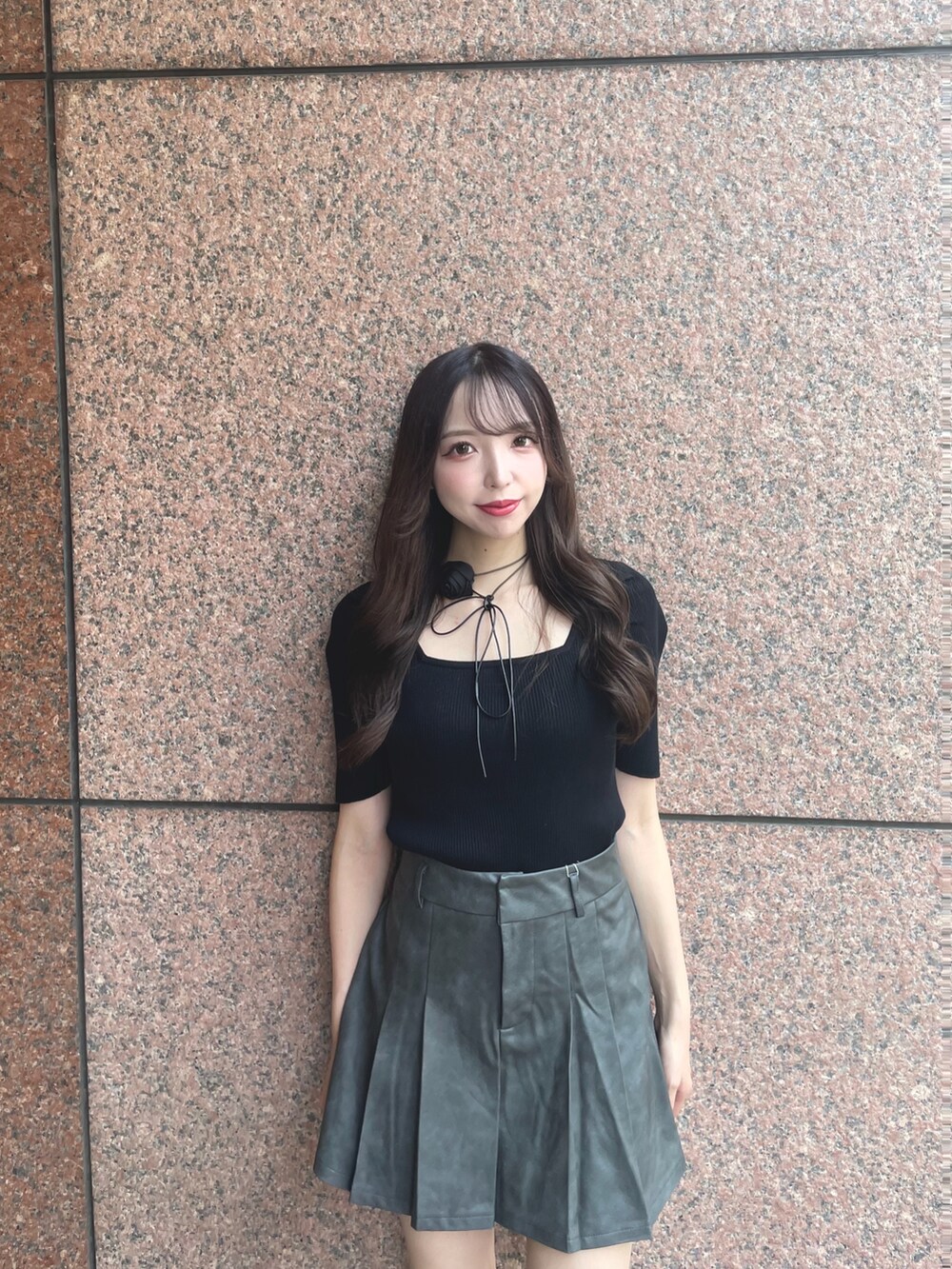 グレー系のスカート、ブラック系のニット/セーターを着用したレディースの夏コーディネートの2枚目の写真