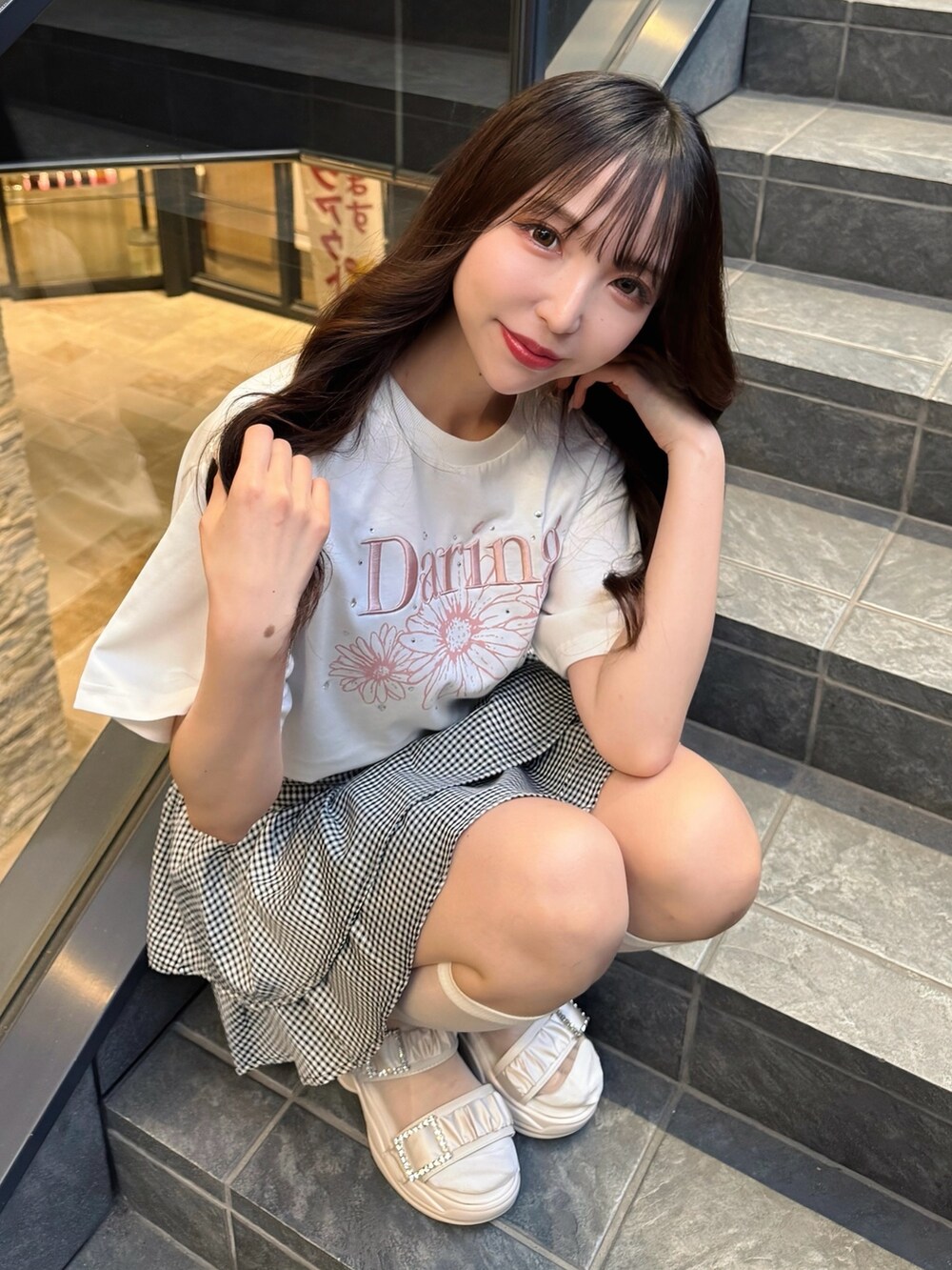 ホワイト系のTシャツ/カットソー、ブラック系のスカート、ホワイト系のサンダルを着用したレディースの春コーディネートの3枚目の写真