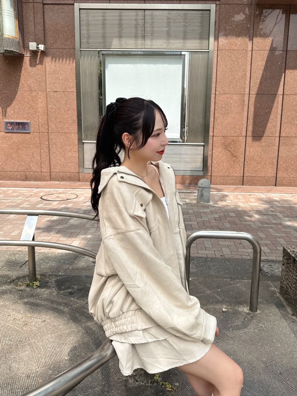 ホワイト系のブルゾン、ホワイト系のキャミソール、ホワイト系のスカートを着用したレディースの秋コーディネートの5枚目の写真