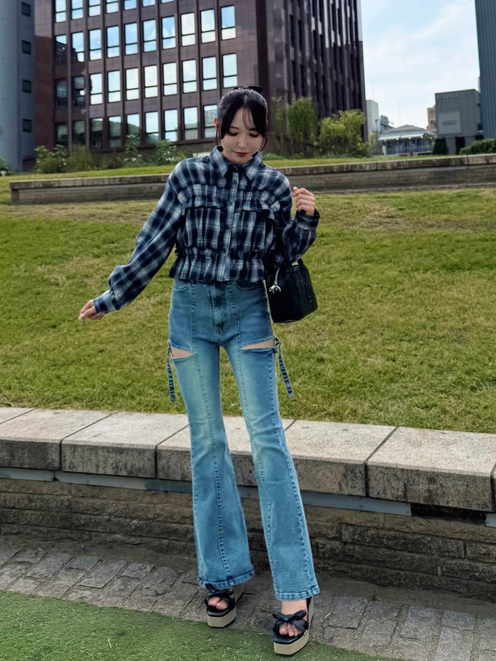 ブルー系のシャツ/ブラウス、ブルー系のデニムパンツ、ブラック系のハンドバッグを着用したレディースの秋コーディネートの3枚目の写真