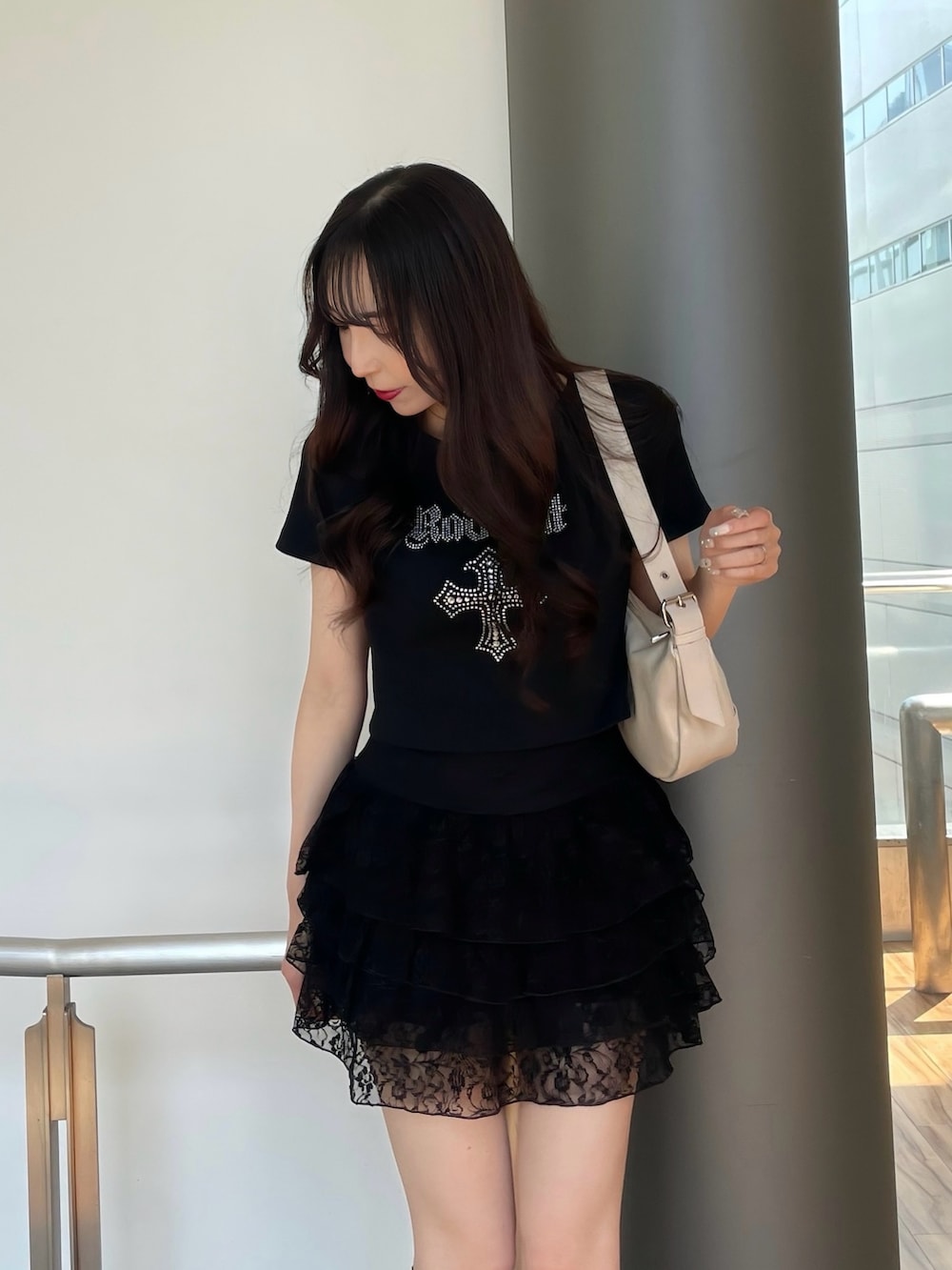 ブラック系のTシャツ/カットソー、ブラック系のスカート、ブラック系のサンダルを着用したレディースの春コーディネートの2枚目の写真