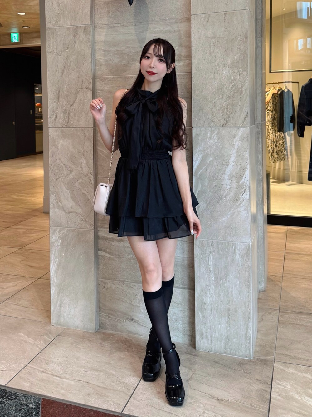 ブラック系のワンピース、ホワイト系のショルダーバッグを着用したレディースの夏コーディネートの3枚目の写真