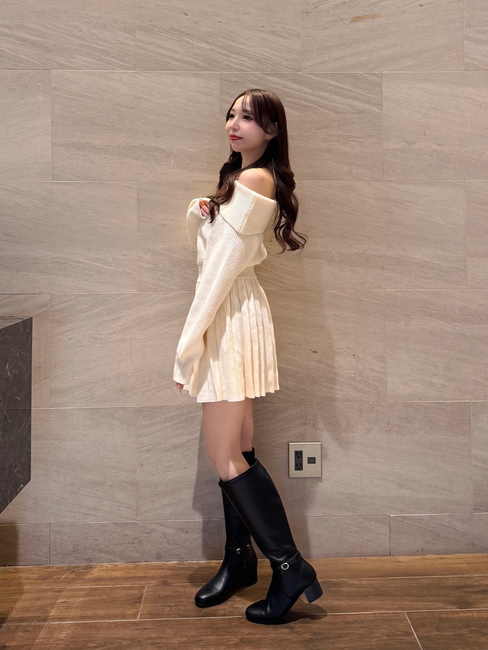 ホワイト系のワンピース、ブラック系のブーツを着用したレディースの冬コーディネートの3枚目の写真