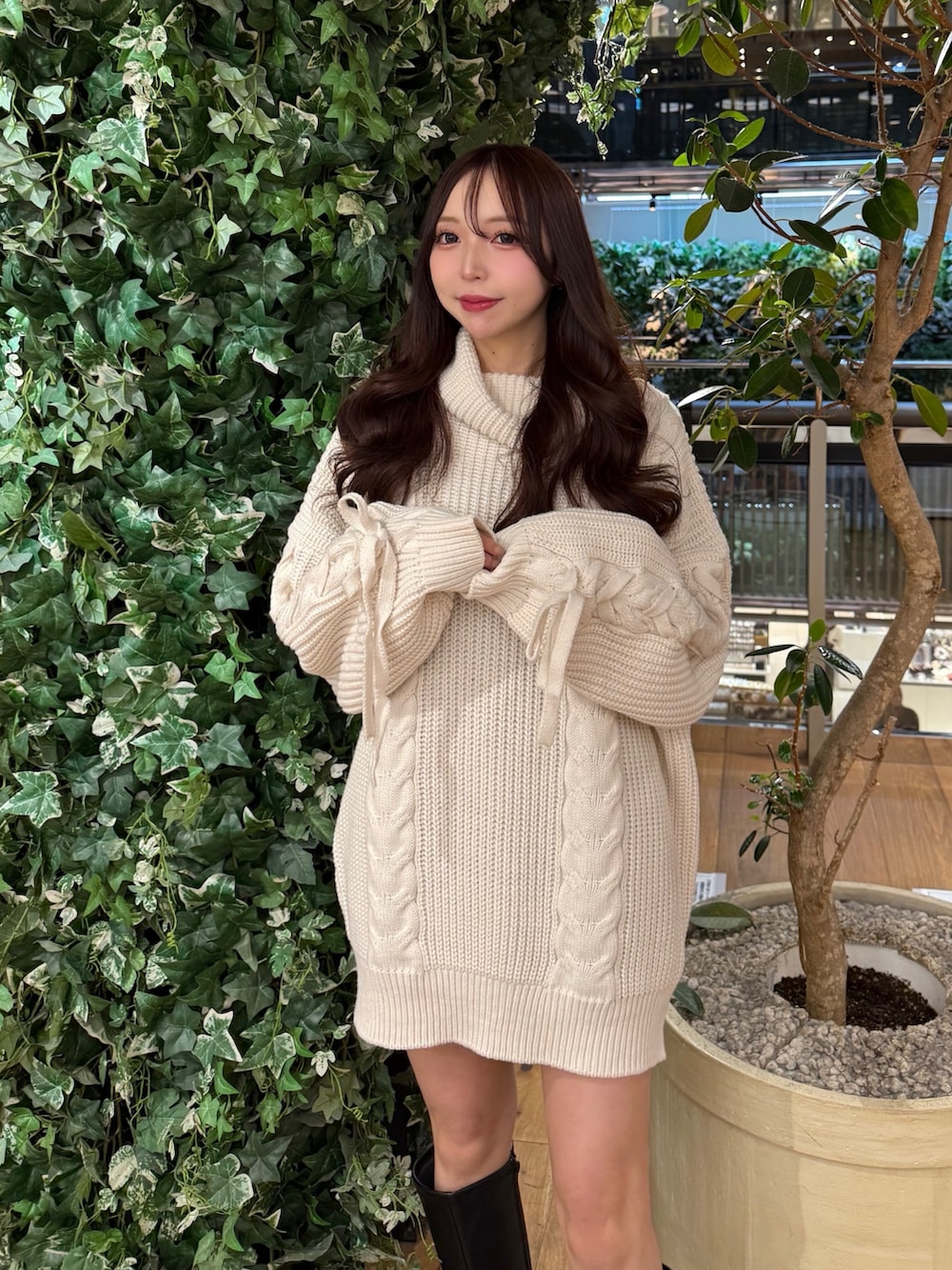 ホワイト系のチュニック、ブラック系のブーツを着用したレディースの冬コーディネートの3枚目の写真