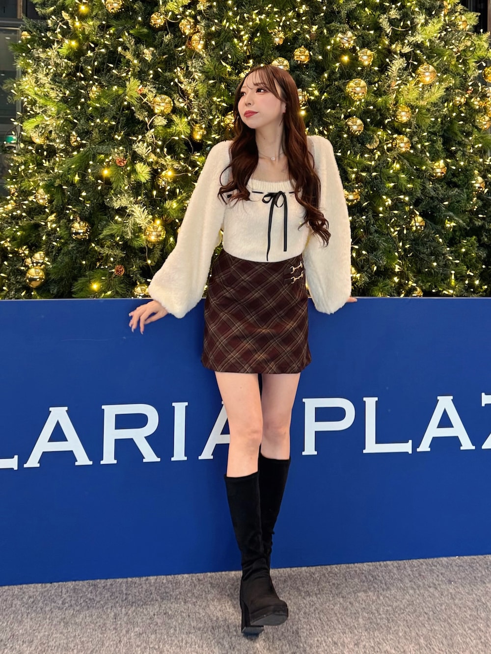 ホワイト系のカーディガン/ボレロ、レッド系のスカートを着用したレディースの冬コーディネートの2枚目の写真