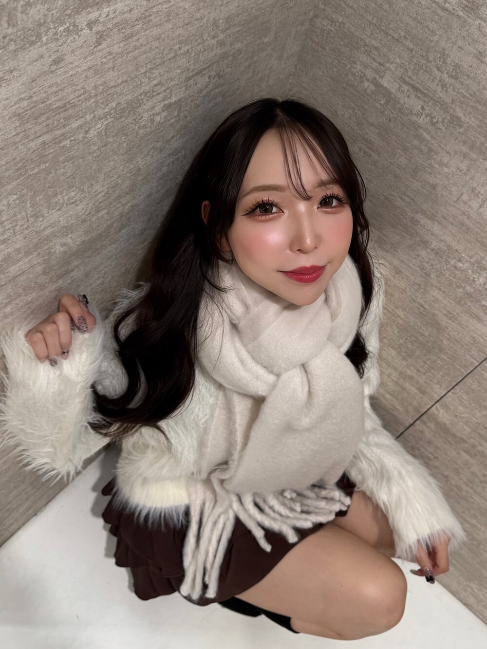 ホワイト系のニット/セーター、ブラウン系のスカート、ホワイト系のストール/ショールを着用したレディースの秋コーディネートの6枚目の写真