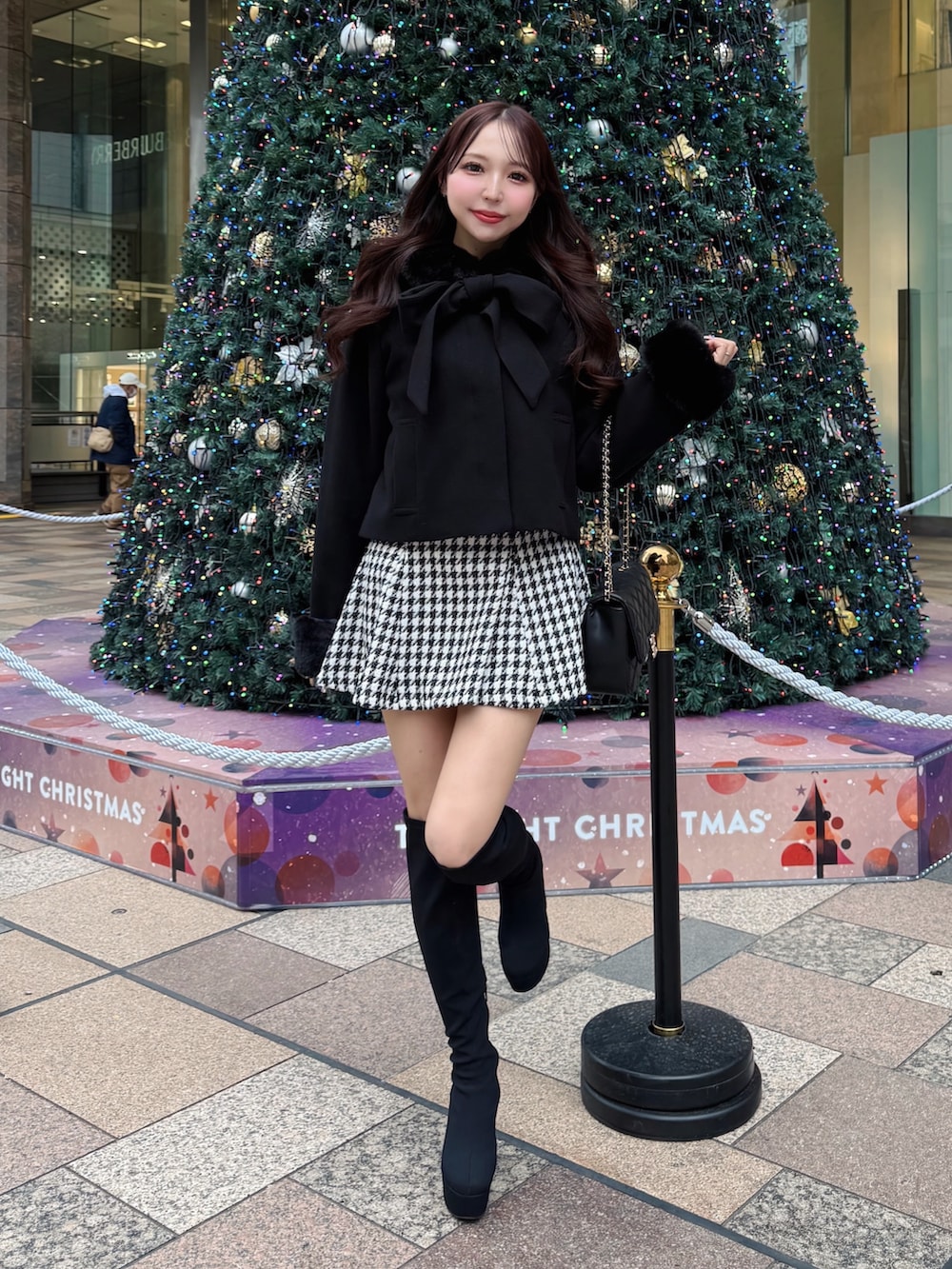 ブラック系のショルダーバッグ、その他のスカート、ブラック系のダウンジャケット/コートを着用したレディースの冬コーディネートの2枚目の写真