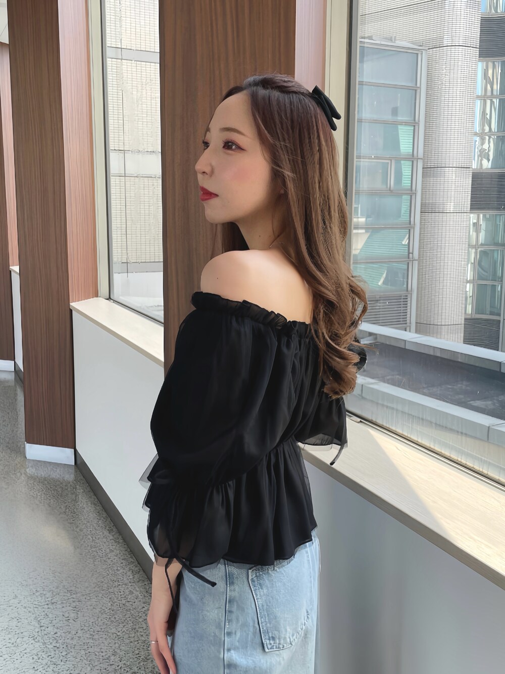 ブラック系のシャツ/ブラウス、ブルー系のデニムパンツ、ホワイト系のパンプスを着用したレディースの春コーディネートの2枚目の写真