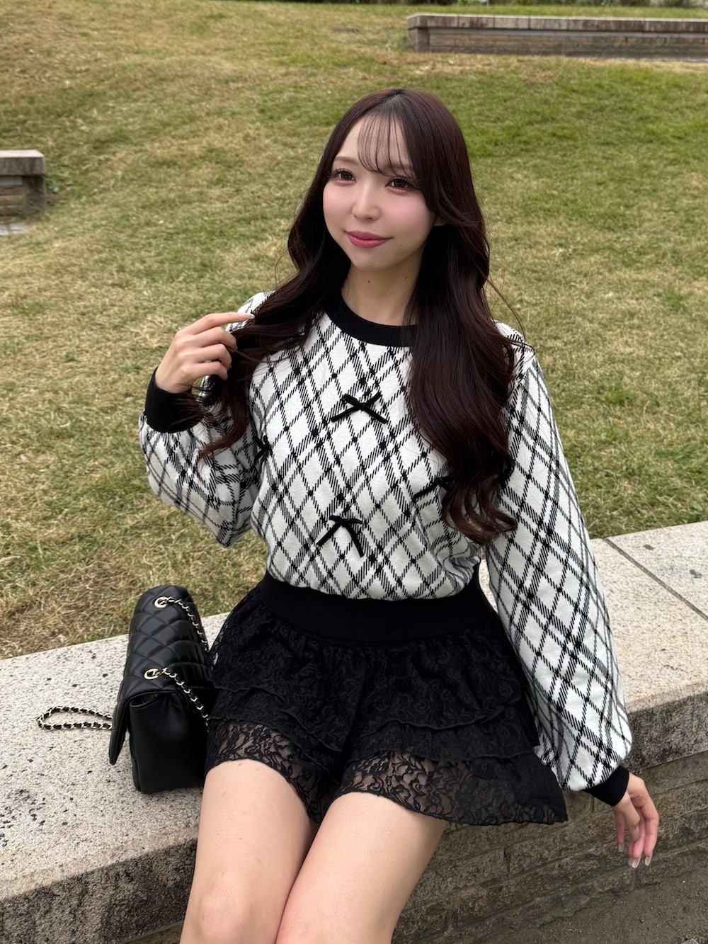 ホワイト系のニット/セーター、ブラック系のスカート、ブラック系のショルダーバッグを着用したレディースの秋コーディネートの2枚目の写真