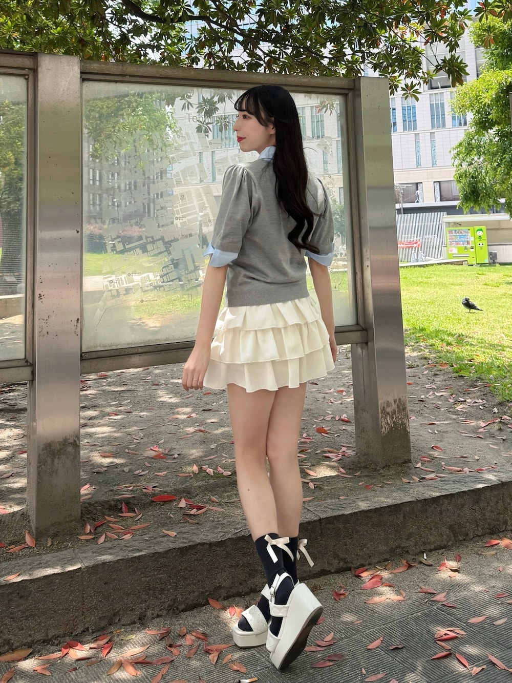 グレー系のニット/セーター、ホワイト系のスカート、ホワイト系のサンダルを着用したレディースの夏コーディネートの2枚目の写真