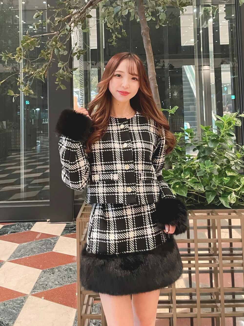 ブラック系のノーカラージャケット、ブラック系のスカートを着用したレディースの秋コーディネートの2枚目の写真