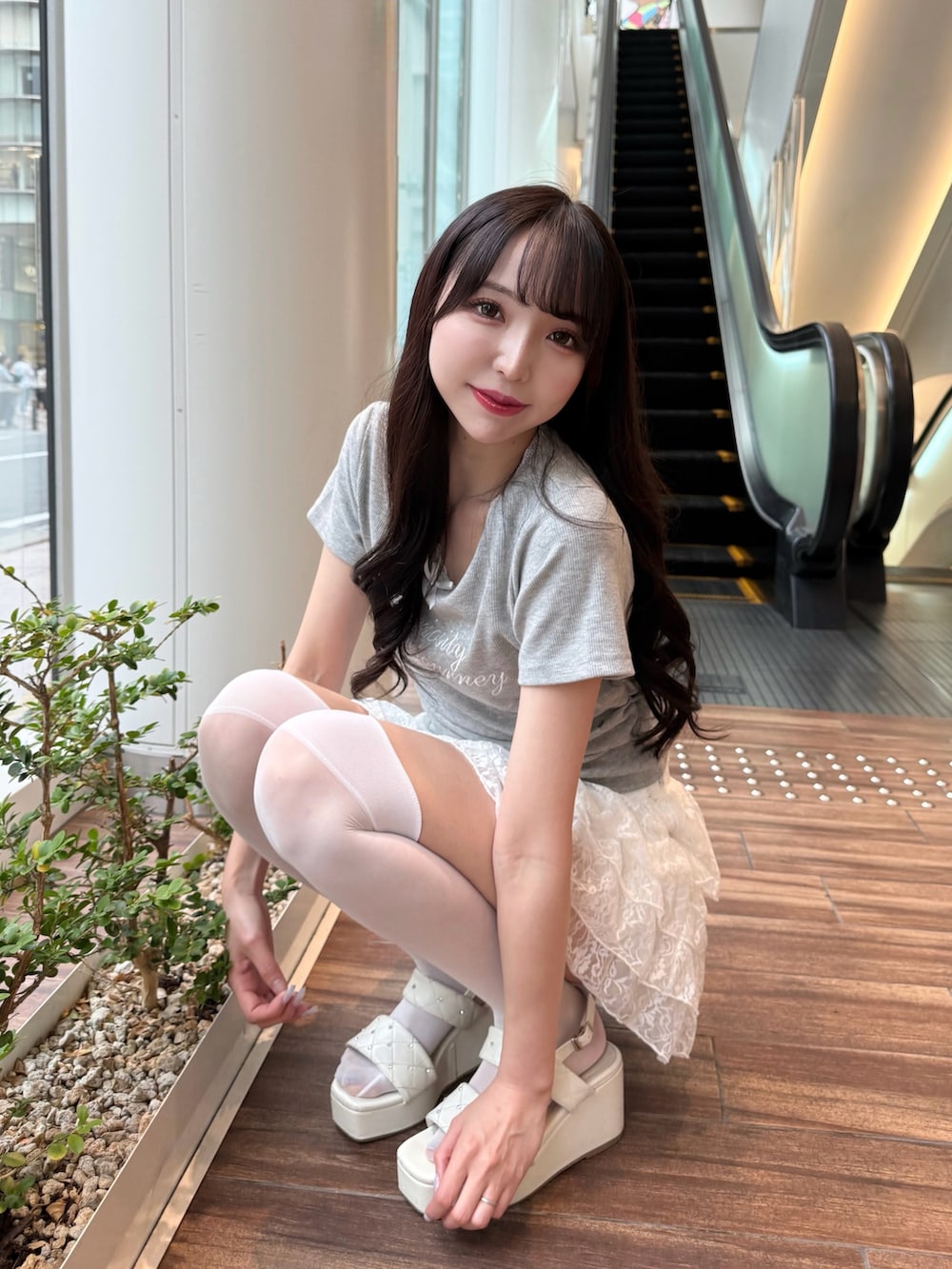 グレー系のTシャツ/カットソー、ホワイト系のスカート、ホワイト系のサンダルを着用したレディースの夏コーディネートの7枚目の写真