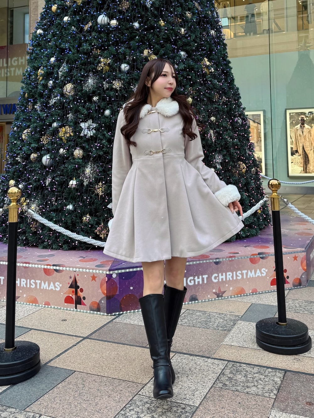 ピンク系のその他アウター、ブラック系のブーツを着用したレディースの冬コーディネートの2枚目の写真