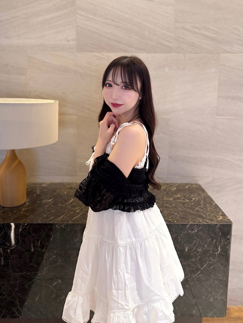 ホワイト系のワンピース、ブラック系のカーディガン/ボレロ、ホワイト系のサンダルを着用したレディースの夏コーディネートの5枚目の写真