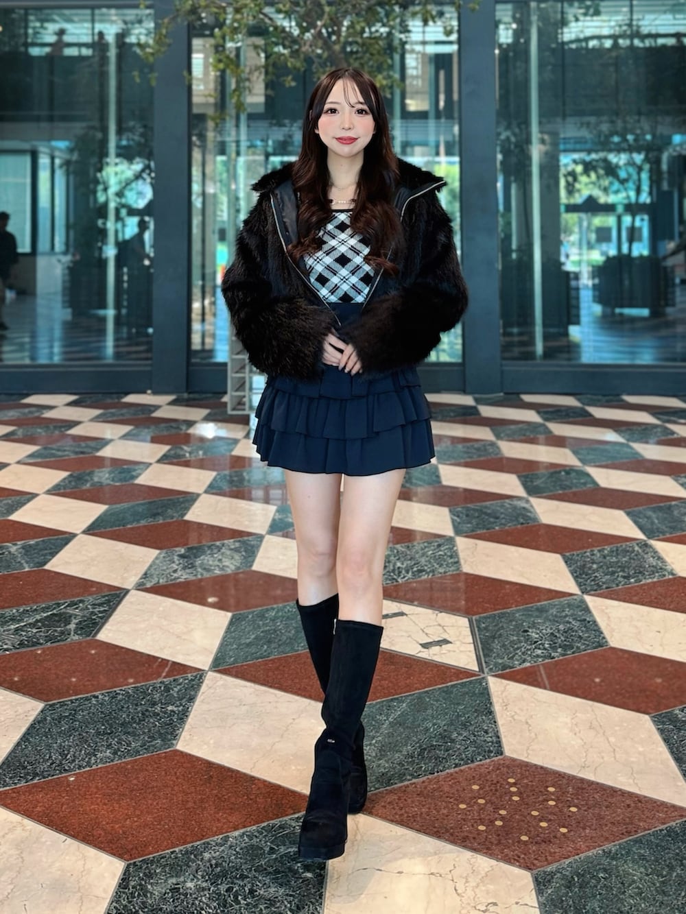 ブラック系のブルゾン、ブラック系のニット/セーター、ブラック系のスカートを着用したレディースの秋コーディネートの2枚目の写真