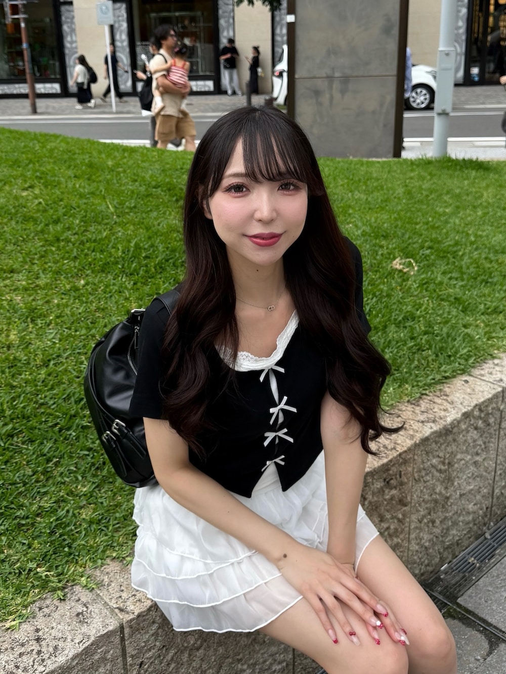 ブラック系のTシャツ/カットソー、ホワイト系のスカート、ブラック系のサンダルを着用したレディースの夏コーディネートの3枚目の写真