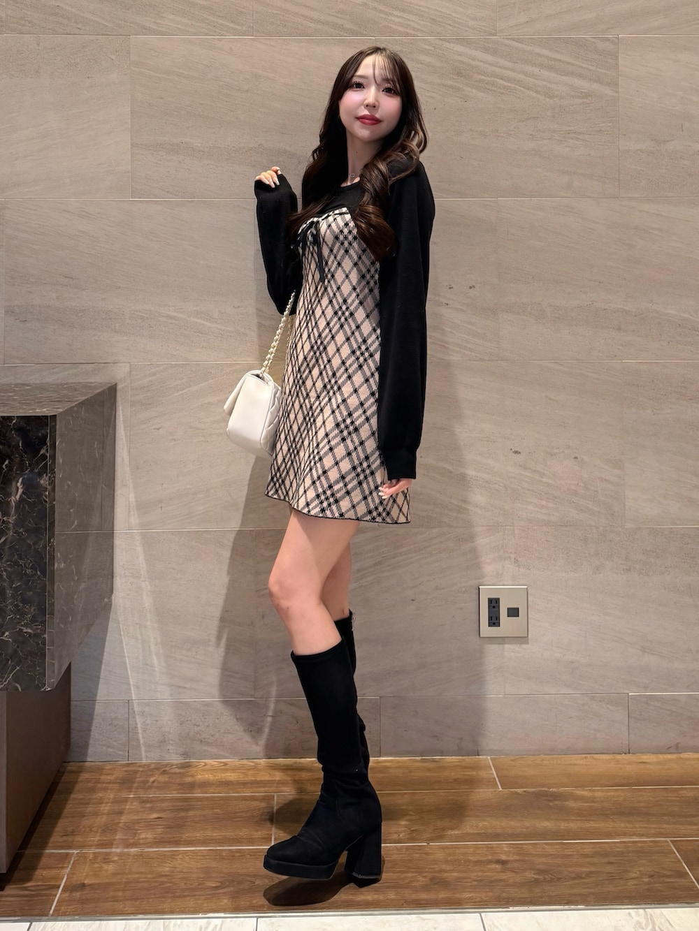 ベージュ系のワンピース、ホワイト系のショルダーバッグを着用したレディースの冬コーディネートの3枚目の写真