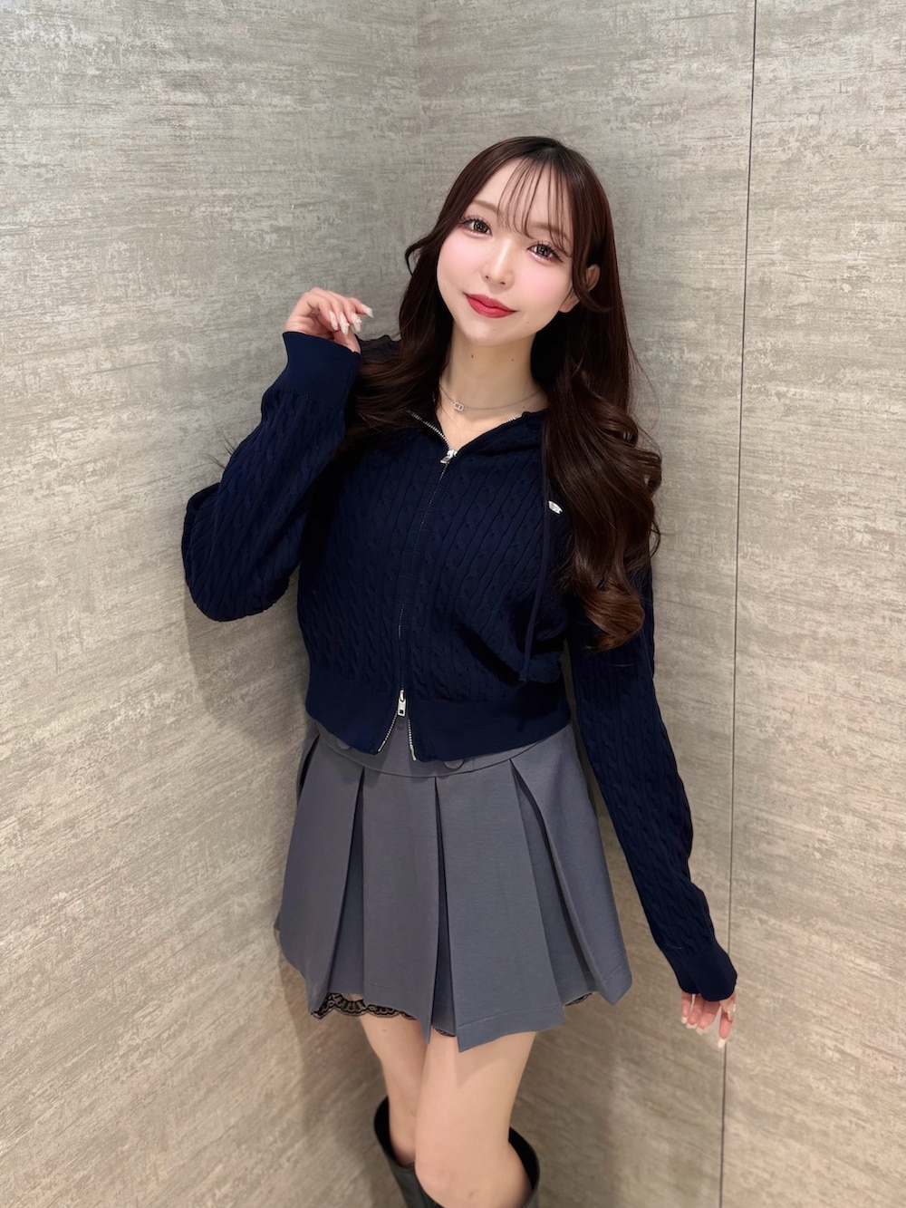 ブルー系のパーカー、グレー系のスカート、ブラック系のブーツを着用したレディースの冬コーディネートの4枚目の写真