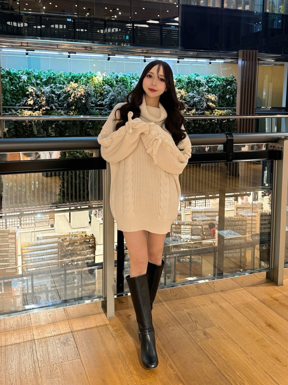 ホワイト系のチュニック、ブラック系のブーツを着用したレディースの冬コーディネートの2枚目の写真