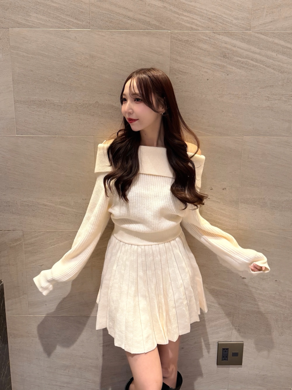 ホワイト系のワンピース、ブラック系のブーツを着用したレディースの冬コーディネートの4枚目の写真