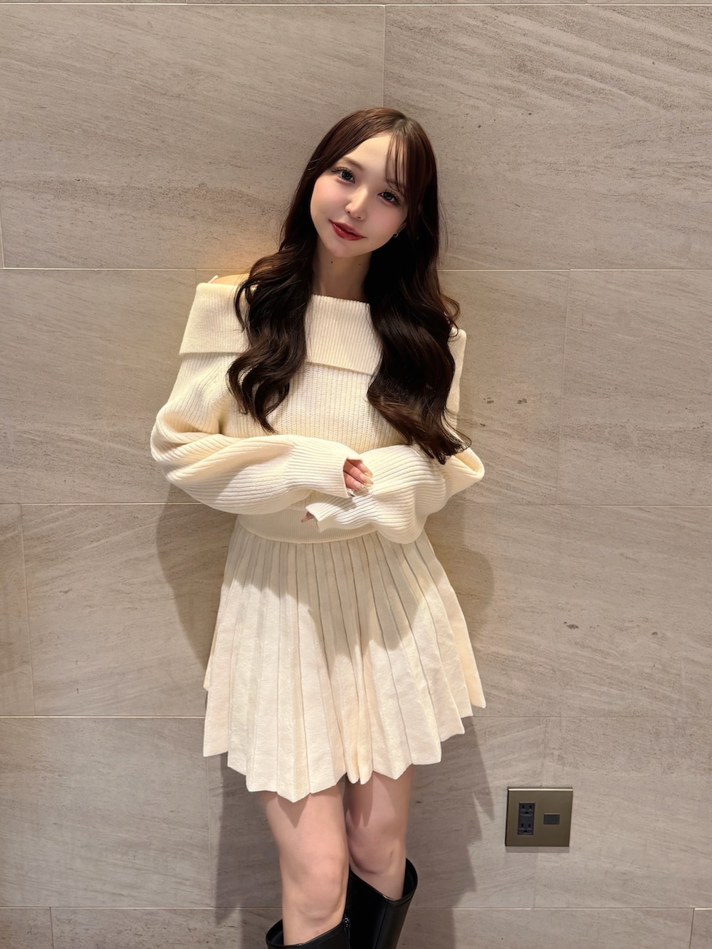 ホワイト系のワンピース、ブラック系のブーツを着用したレディースの冬コーディネートの5枚目の写真